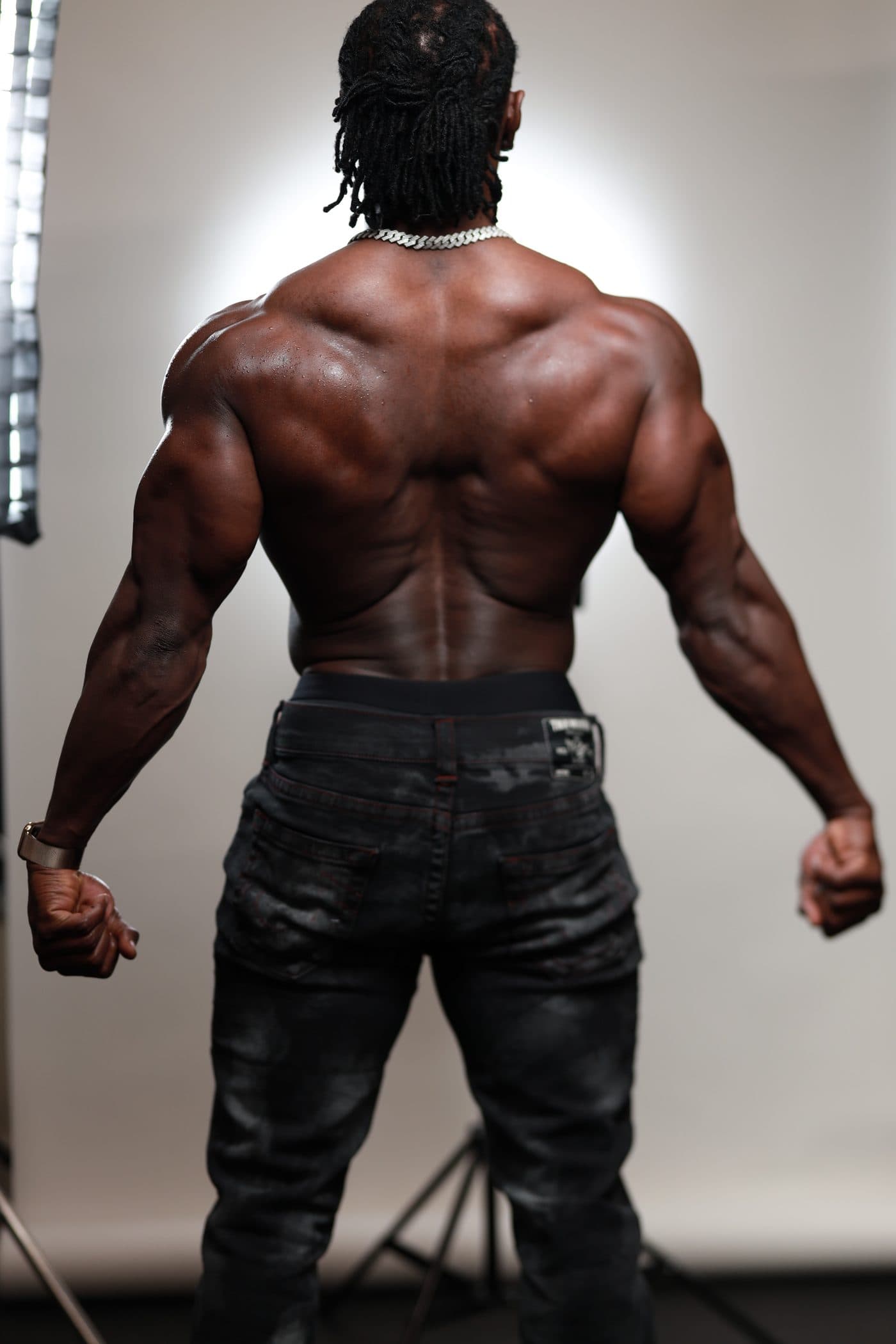 Alseny Sylla showing developed back and shoulder musculature in a studio shot